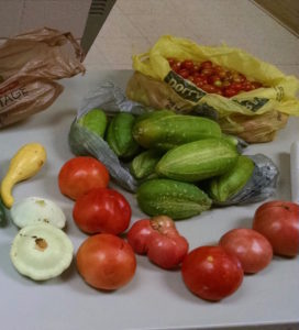 tomatoes, squash, cucumbers, yellow plastic bag with cherry tomatoes
