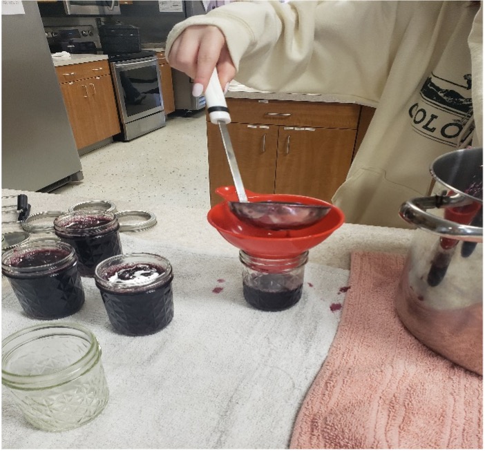 HHS Nutrition Class student canning homemade grape jelly.