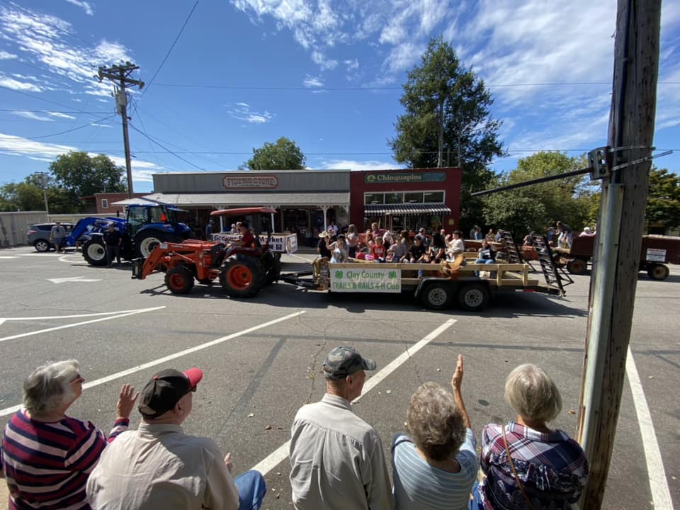 parade attendees waving to people riding on a trailer