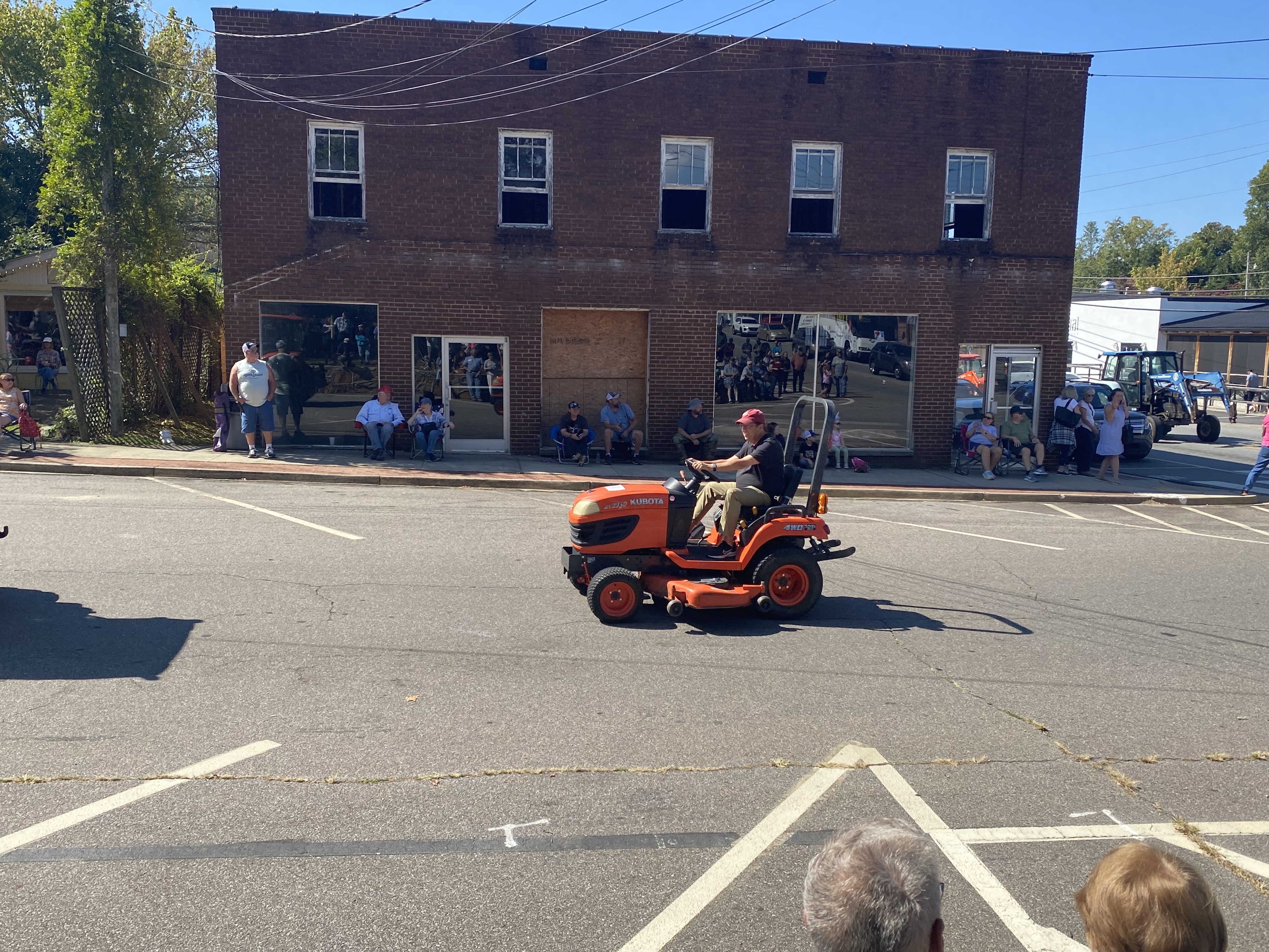 Small orange tractor in parade