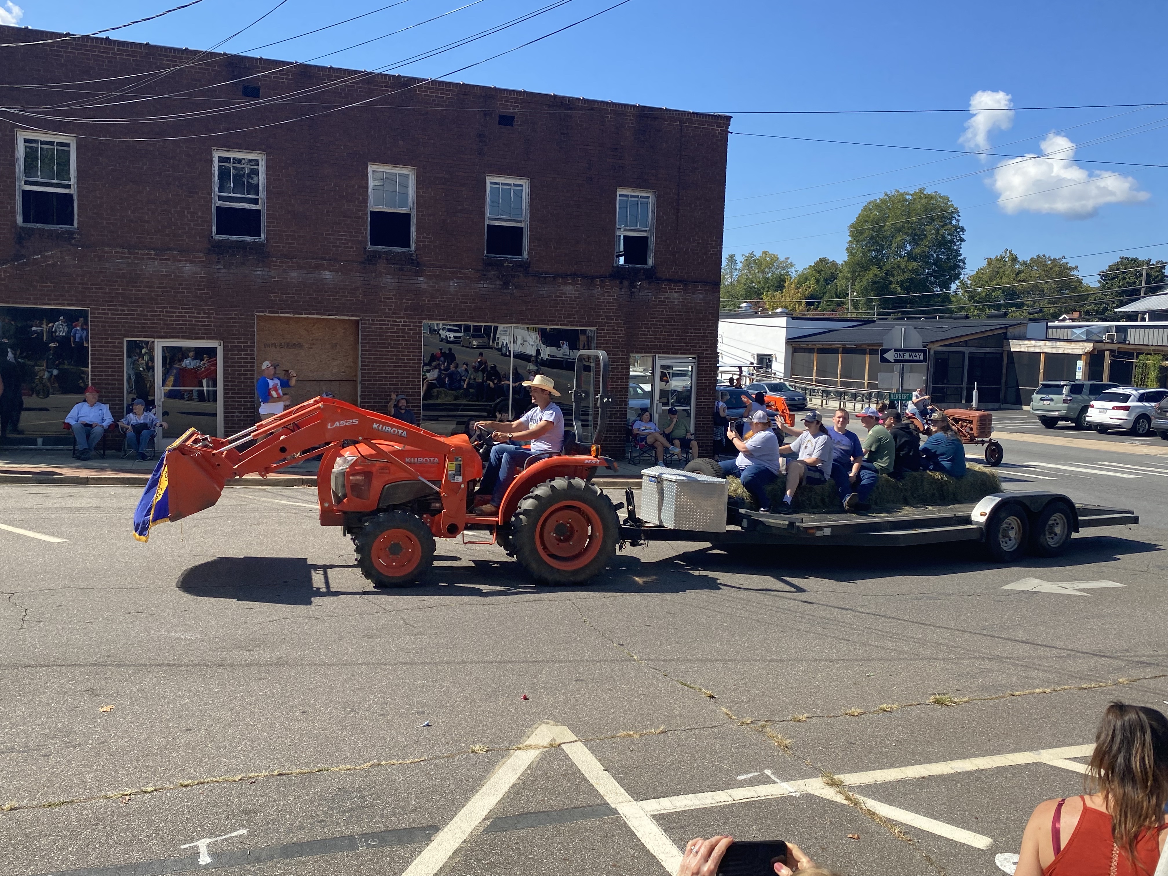 orange tractor with trailer full of people