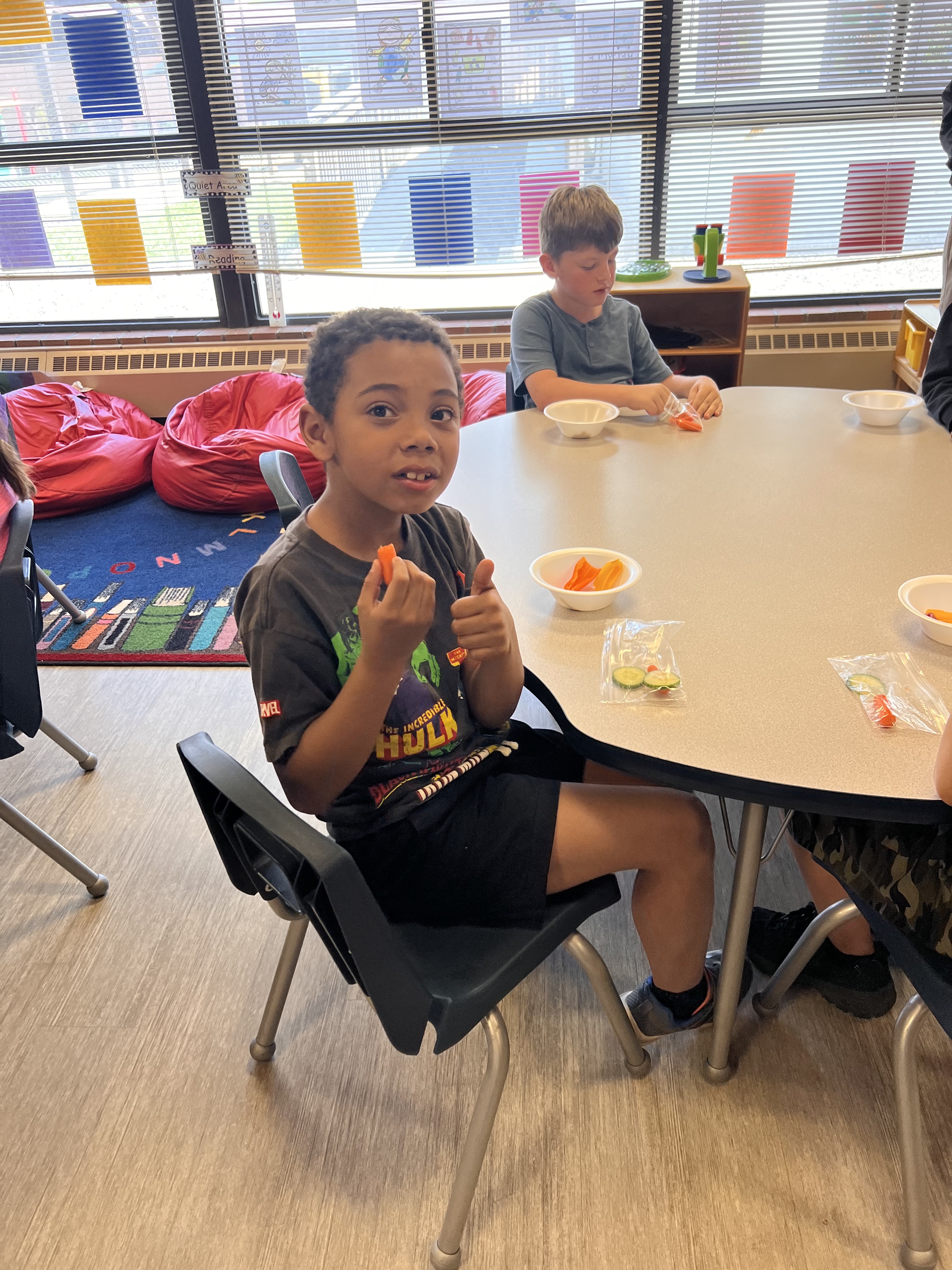 Kids eat snacks at a table.